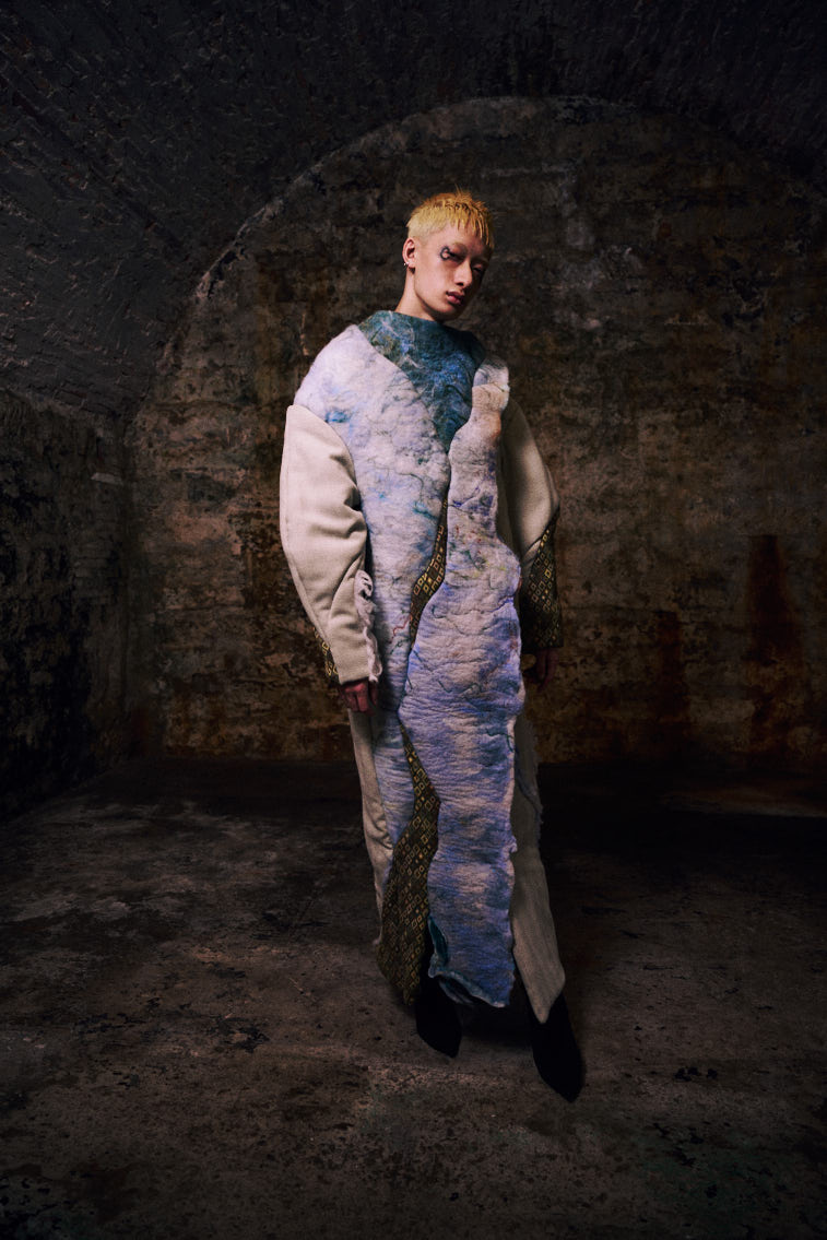 a man wear a blue tone color wool felting cloth in historic place, in tunnel