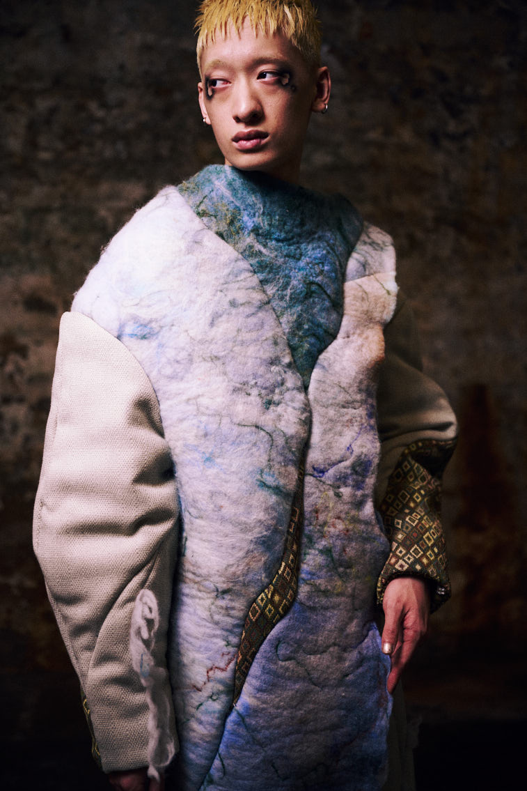 a man wear a blue tone color wool felting cloth in historic place, in tunnel