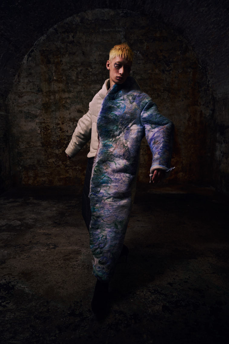 a man wear a blue tone color wool felting cloth in historic place, in tunnel