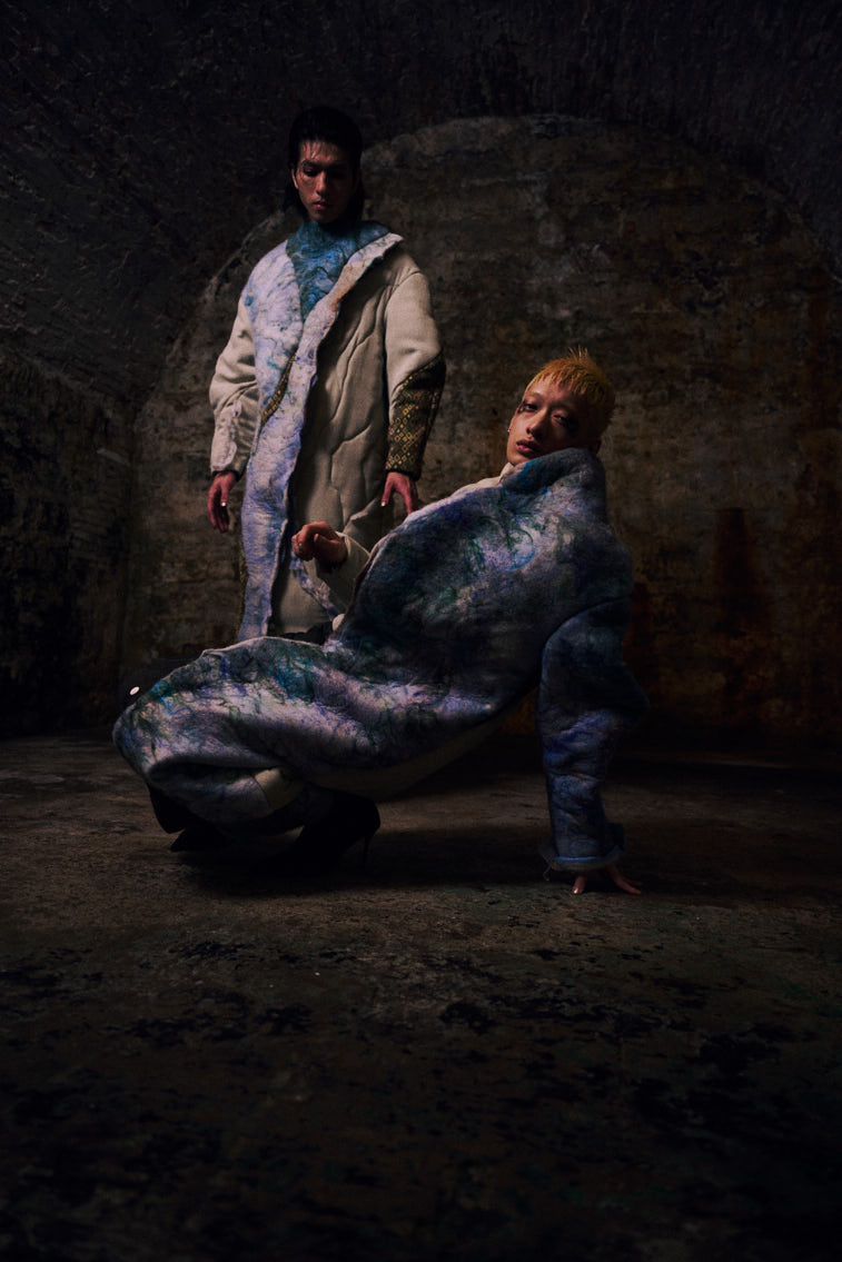 two men wear a blue color wool felting cloths in historic place, in tunnel