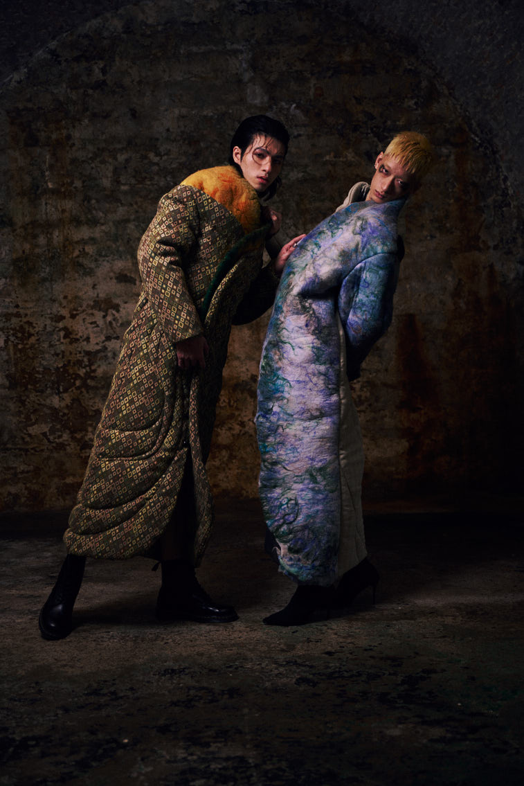 two men wear wool felting cloths in historic place, in tunnel