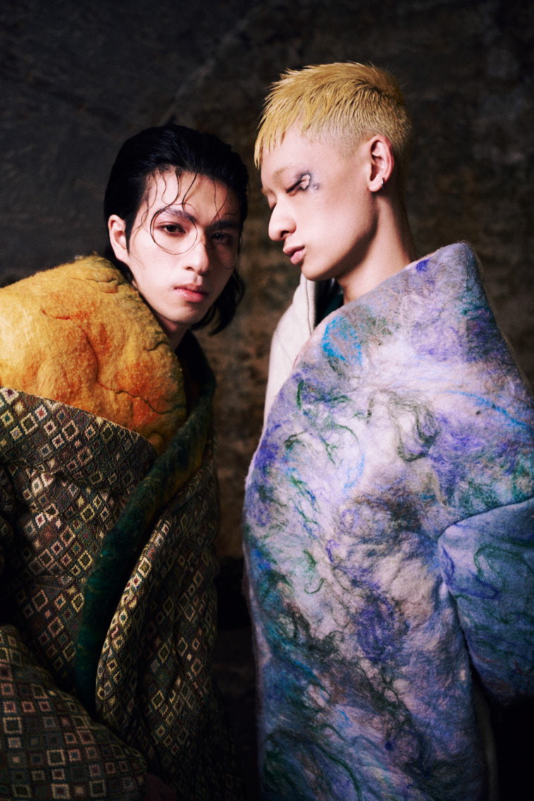two men wear wool felting cloths in historic place, in tunnel