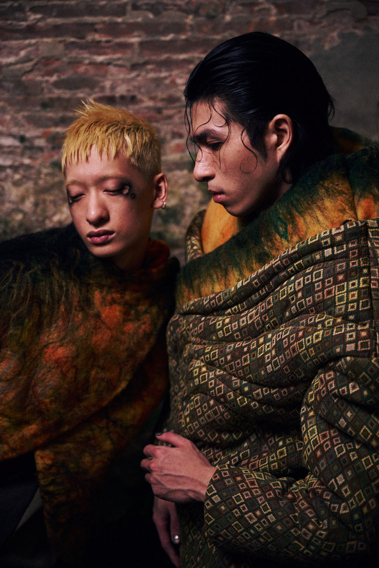 two men wear a warn color wool felting cloths in historic place, in tunnel