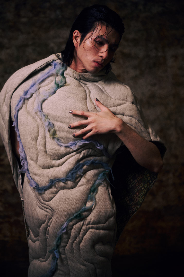 a man wear a blue tone color wool felting cloth in historic place, in tunnel