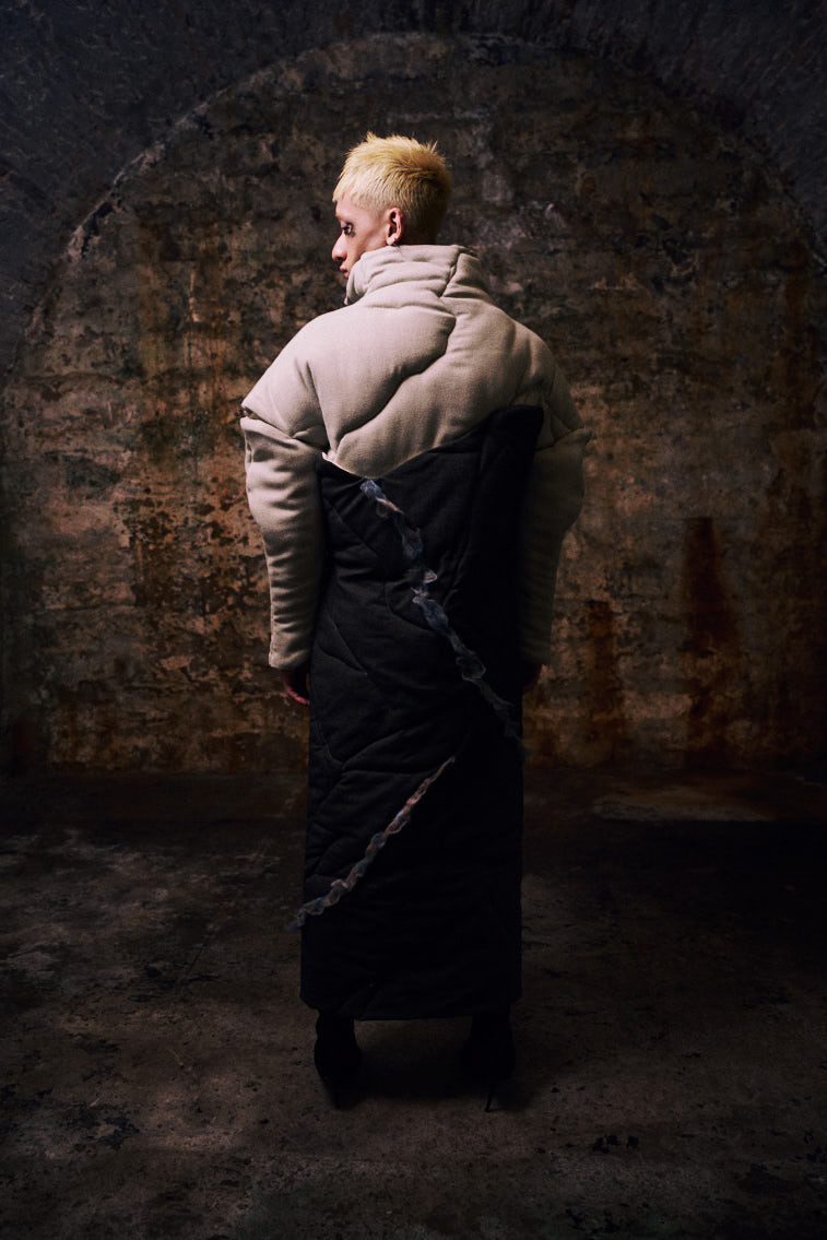 a man wear a blue tone color wool felting cloth in historic place, in tunnel